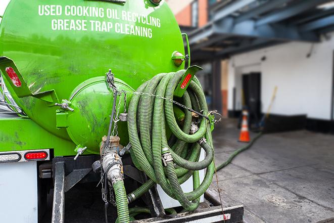 a technician pumping a grease trap in a commercial building in Everett, MA